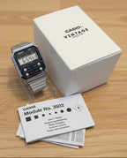 Casio watch with packaging and manual on a light gray background