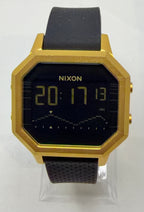 Gold and black digital watch with 'Nixon' branding on a white background