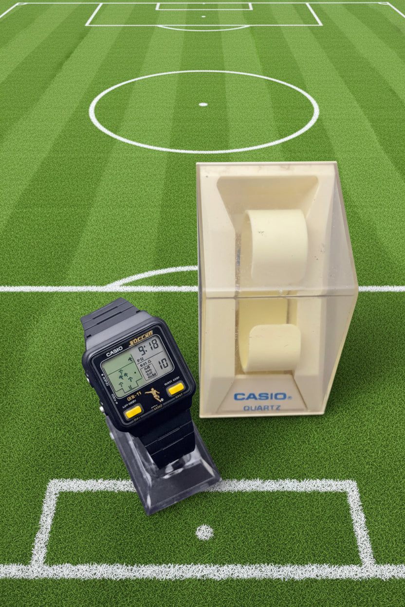Casio digital watch on a dark surface with packaging