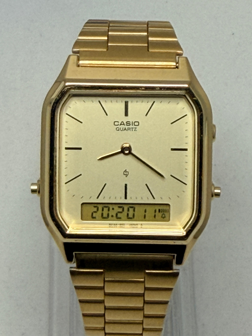 Gold Casio watch on a light gray background