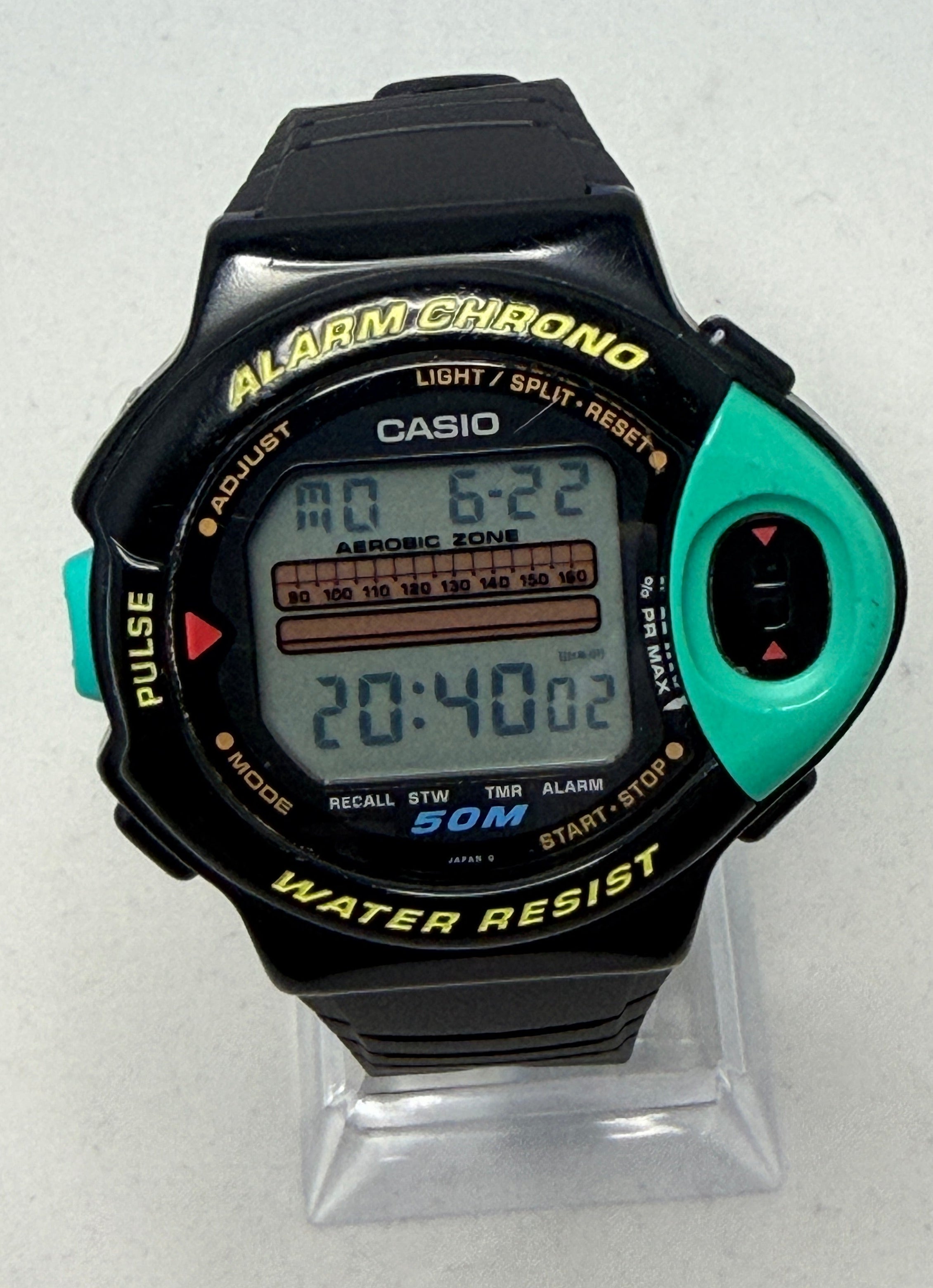 Digital watch with green and black casing on a white background