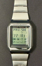 A Casio digital wristwatch with a silver metal link band, shown flat against a dark gray background.