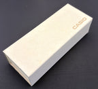 A light beige Casio product box with the brand name printed in orange, resting on a dark surface.